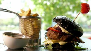 délicieux Burger avec noir chignon suivant à frit patates sur restaurant table video