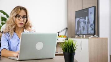 freelancer vrouw werken Aan de laptop en haar vriendje is maken een veel van lawaai in de achtergrond terwijl wathing TV. hij is verstorend haar. 4k dolly beeldmateriaal video