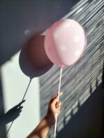 Happy child holding colorful balloon, celebrating with friends, with shadow and light photo