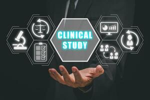 Clinical study concept, Businessman hand holding clinical study icon on virtual screen. photo
