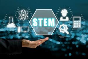 Stem concept, Business woman hand holding stem icon on virtual screen with blue vokeh background. photo