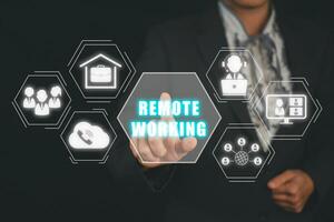 Remote working concept, Business person hand touching remote working icon on virtual screen. photo