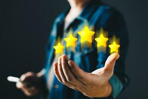 hand of customer or client holding the stars to complete five stars with copy space.Service rating,giving a five star rating.satisfaction concept. photo