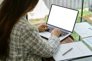 Woman Working by using laptop blank screen computer . Hands typi photo