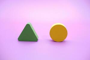 conjunto de vistoso de madera forma juguete. triángulo y redondo en púrpura antecedentes foto