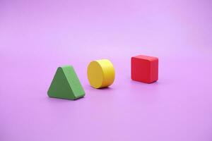 Set of colorful wooden shape toy. Square, triangle and round on Purple background photo