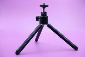 mini tripod for phone isolated on purple background photo