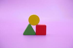 Set of colorful wooden shape toy. Square, triangle and round on Purple background photo