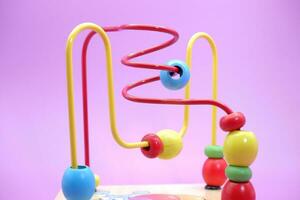 para niños educativo juguete aislado en púrpura antecedentes. niñito juguetes juguetes con hierro cable y rosario. foto