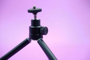 mini tripod for phone isolated on purple background photo