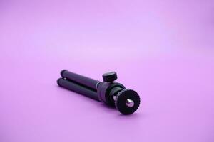 mini tripod for phone isolated on purple background photo