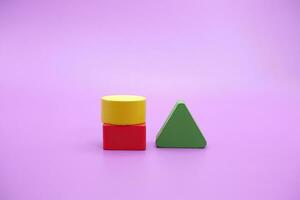 Set of colorful wooden shape toy. Square, triangle and round on Purple background photo