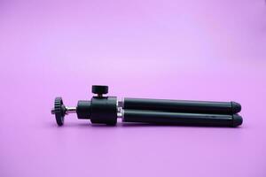 mini tripod for phone isolated on purple background photo