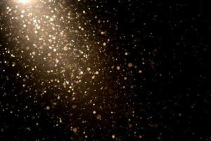 Organic dust particles floating in light ray on black background. Glittering sparkling flickering glowing. photo