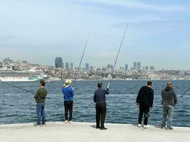 15 de abril 2023 - Estanbul, Turquía - pescadores en el frente al mar foto