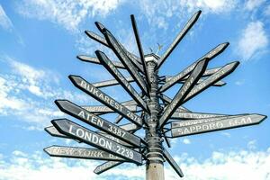 a pole with many directional signs on it photo