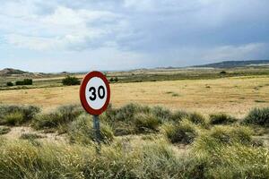 a speed limit sign in the middle of a field photo