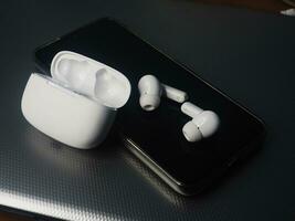 white earbuds and smart phone connect together photo