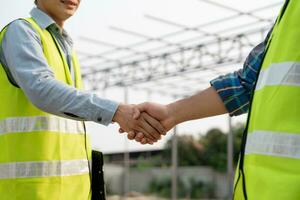 Construction team hands shaking greeting start up plan new project contract in office center at construction site, industry ,architecture, partner, teamwork, agreement, property, contacts. photo