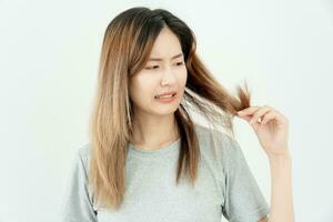 Asian woman very sad and upset looking at damaged hair, hair loss, hair thinning problem, vitamin deficiency, baldness, postpartum, biotin, zinc, menstrual or endocrine disorders, hormonal imbalance photo