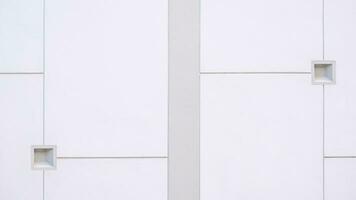Background of modern white and gray concrete fence wall with 2 little square cubic shape and geometric lines on surface in minimal style photo