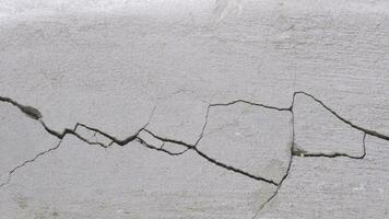 Cracks and broken texture of damaged concrete wall or floor background photo