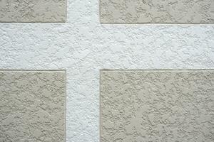 White cross pattern on beautiful decorative roughness texture surface of gray concrete wall outside of vintage house building photo