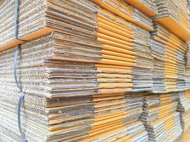 Group of many brown foldable cardboard boxes stacked for packaging in perspective side view photo