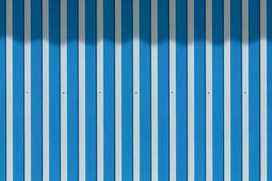 Background of white and blue striped aluminum steel wall with shadow of canvas awning on surface photo