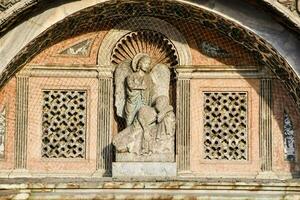 a statue of an angel is on the side of a building photo