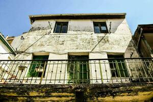 an old house with a balcony and green railings photo