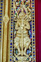 a gold and blue ornate wall decoration with a statue photo