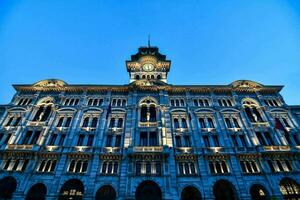 the building is lit up at night with a clock tower photo