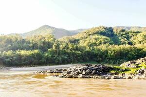 a river with rocks and trees in the background photo