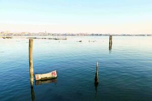 a boat sits in the water near wooden posts photo