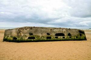 a large concrete bunker sits on the beach photo