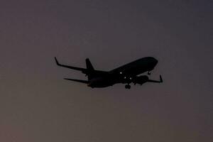 a jetliner flying in the sky at dusk photo