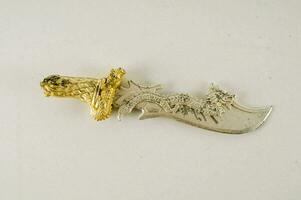 a silver and gold knife with a dragon on it photo