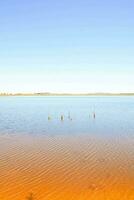 un lago con naranja agua y un azul cielo foto