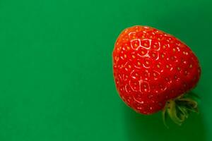 Ripe strawberry on a green background photo