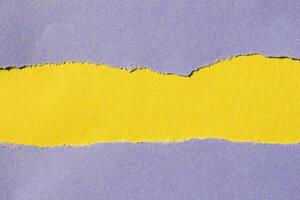 Purple torn paper background. Ripped paper on yellow background with copy space for text. photo