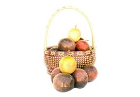 isolated Passion fruit in a bamboo basket on white background. The passion fruit has an oval shape, a thick, oily rind. There are many seeds inside the fruit. It is a healthy fruit with high fiber. photo