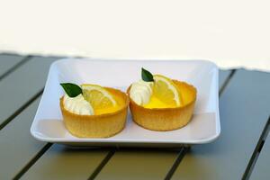 Lemon tart has a crisp, fragrant tart dough paired with sweet and sour lemon cream. It's great as a snack with coffee or cold drinks, which is another popular menu item in coffee shops. photo