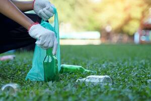 An Asian boy is a student in the Environmental Club and his friends help collect and sort waste plastic water bottles and glass bottles for recycling or reuse. In the concept of saving the world. photo