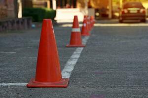 Traffic cones lay on the side of the road. Set up to designate a parking prohibited area along the line because it obstructs the exit. Soft and selective focus. photo