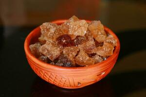 Cubes of organic palm tree rock sugar in a bowl on a black background photo