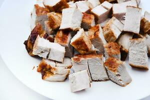 piezas de frito Cerdo carne en un blanco lámina. jugoso y delicioso piezas de parilla carne. foto