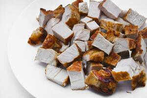 Pieces of fried pork meat on a white plate. Juicy and delicious pieces of barbecue meat. photo