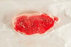 a piece of raw beef on a piece of paper photo