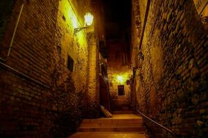 a narrow alley with steps leading up to a lighted street photo